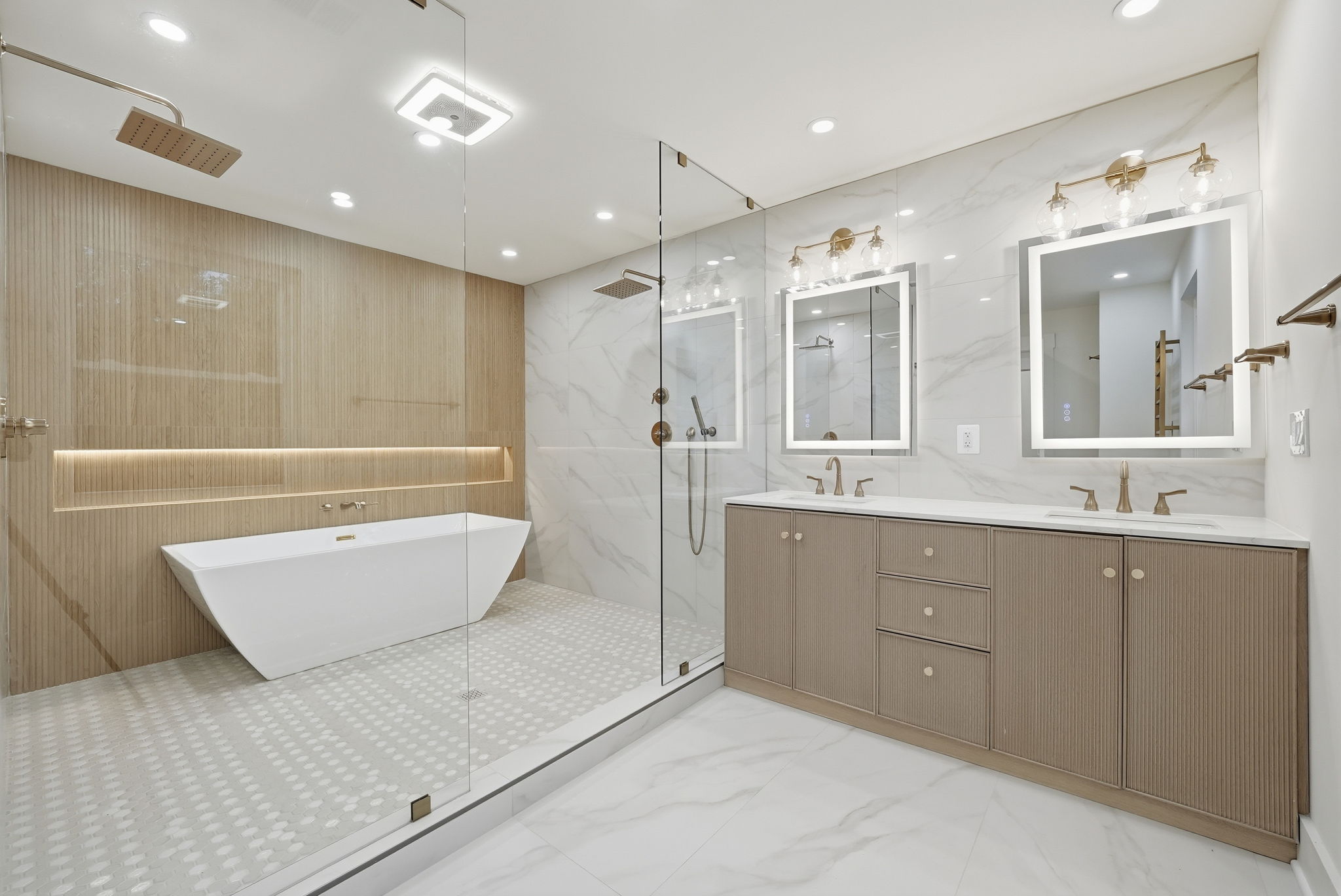Luxury spa-inspired bathroom renovation with freestanding soaking tub, large glass shower, wood accent wall, LED niche lighting, double vanity, and marble-style tile in Arlington, VA